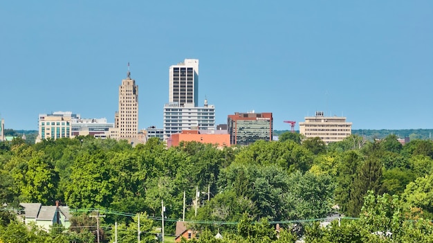 Foto gebäude in der innenstadt von fort wayne mit grüner waldlinie und klarem blauen himmel aus der luft