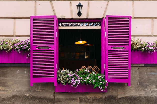 Gebäude mit violetten Fenstern und Fensterläden