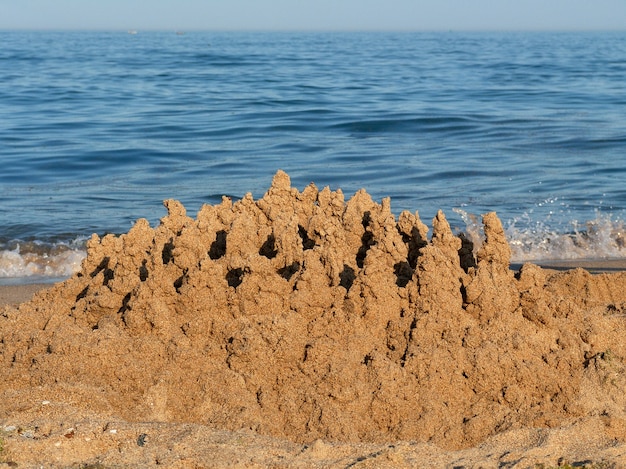 Gebautes Haus Sandburg mit Türmen am Südufer des Sandstrandes blaues Meer