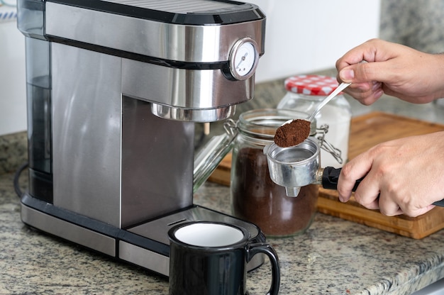 Geben Sie den Kaffee mit einem Löffel in den Filter für einen Kaffee zu Hause.