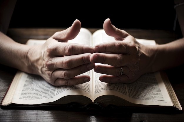 Gebetende Hände auf der geöffneten heiligen Bibel