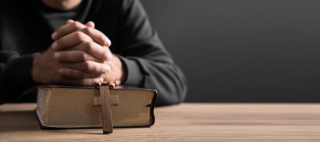 Foto gebetsmann hält kreuz mit bibel