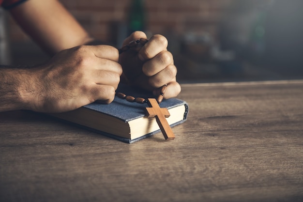 Gebetsmann und Holzkreuz auf der Bibel auf dem Tisch