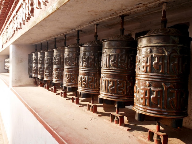 Gebetsräder aus Metallmessing an der Wand des Hariti-Schreins oder des Ajima-Hindu-Tempels in der Swayambhunath-Pagode oder des Affentempels für nepalesische Menschen und ausländische Reisende drehen sich respektvoll beim Beten in Kathmandu Nepal