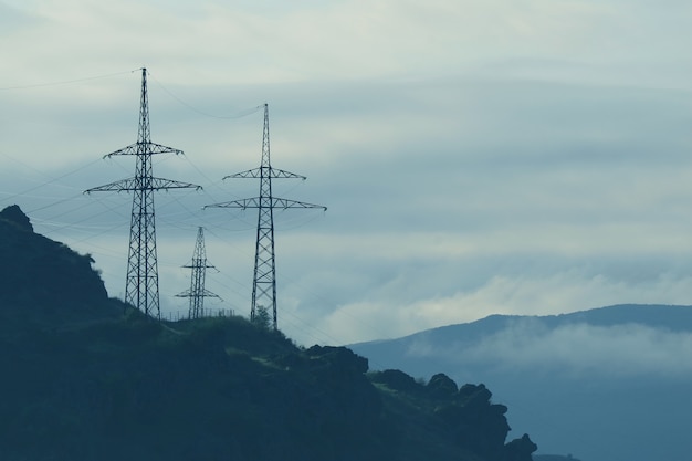 Gebirgszüge mit Hochspannungsmasten im Morgennebel