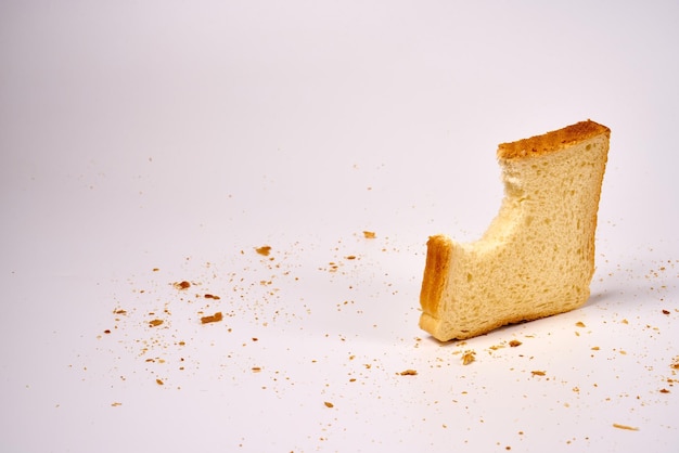 Gebissene Scheibe Toastbrot auf einem weißen, isolierten Hintergrund.