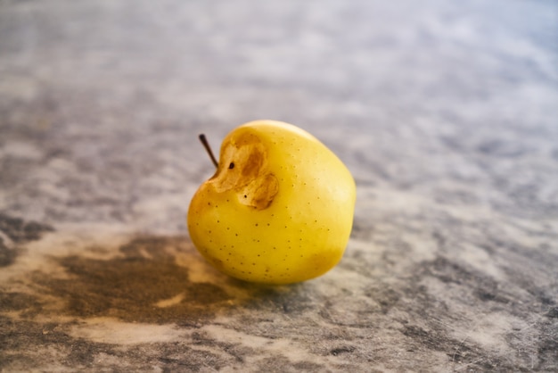 Gebissener gelber Apfel auf dem Tisch