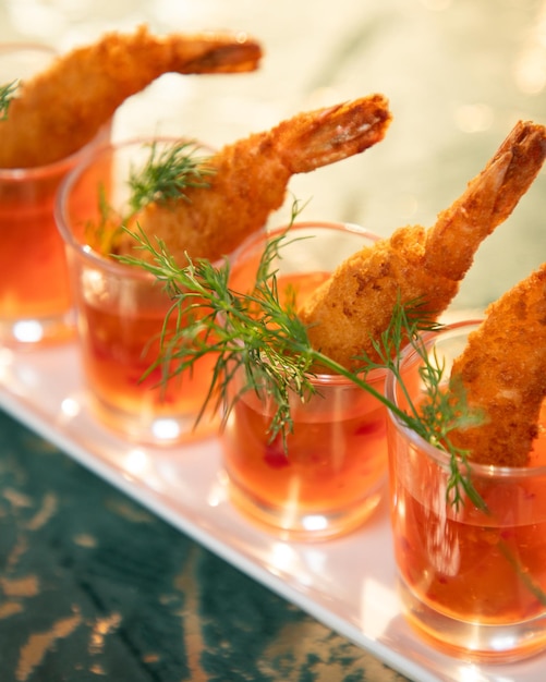 Gebräunte Garnelen mit Sauce, serviert in Schnapsgläsern