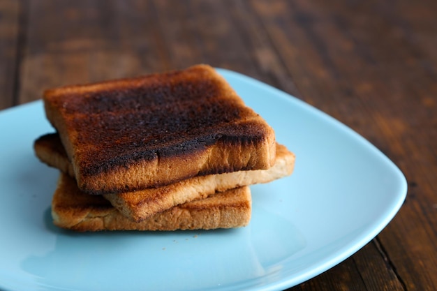 Gebranntes Toastbrot auf Türkisplatte auf Holztischhintergrund