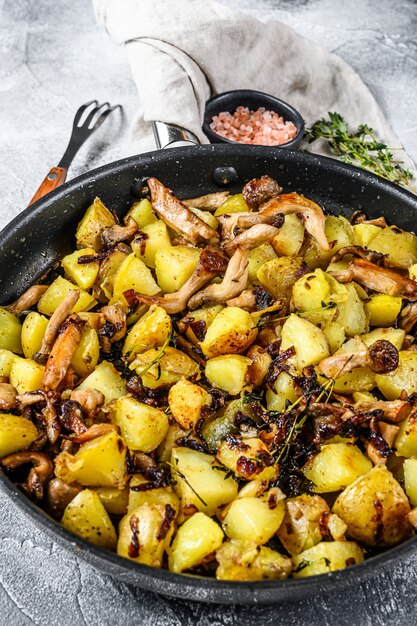 Foto gebratene austernpilze mit kartoffeln in einer pfanne. ansicht von oben.