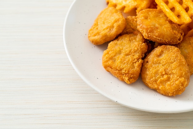 Foto gebratene chicken nuggets mit bratkartoffeln auf teller