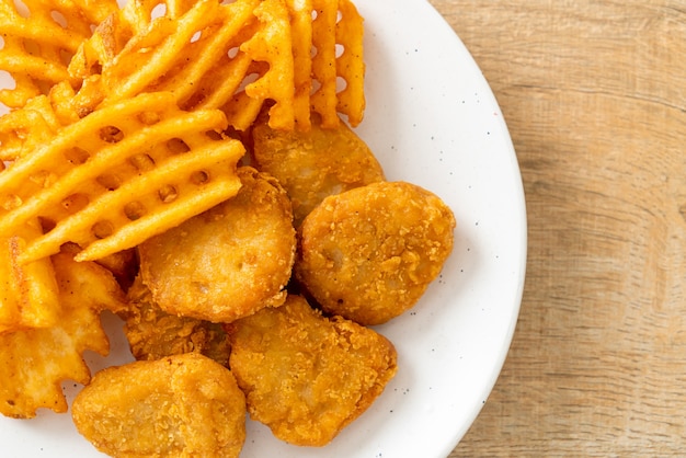 gebratene Chicken Nuggets mit Bratkartoffeln auf Teller