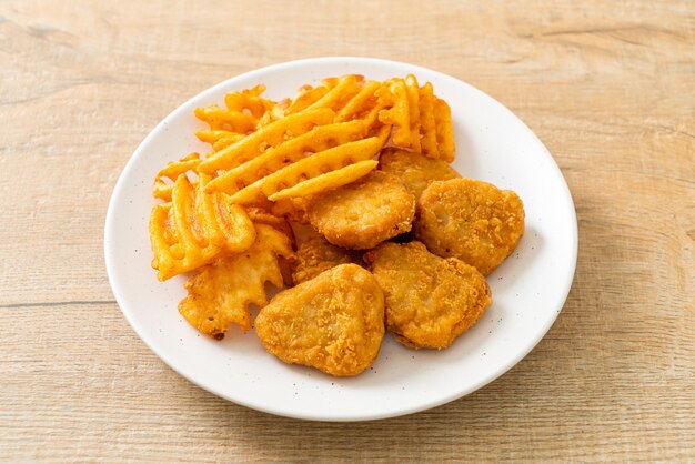 gebratene Chicken Nuggets mit Bratkartoffeln auf Teller