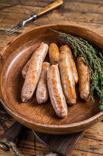 Gebratene Chorizo- und Bratwurstwürste in einer Holzplatte. hölzerner Hintergrund. Ansicht von oben.