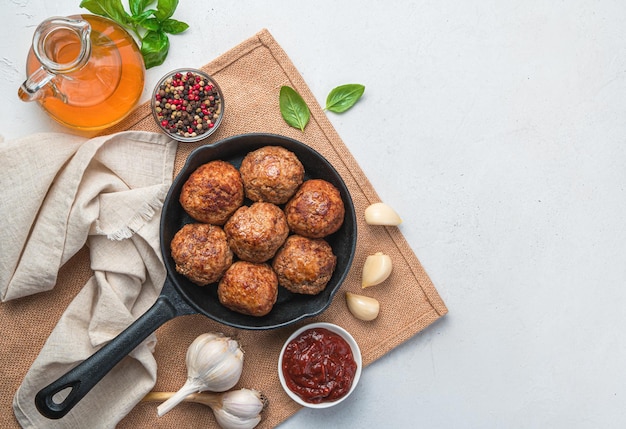 Gebratene Frikadellen mit Gewürzen und Sauce auf grauem Hintergrund