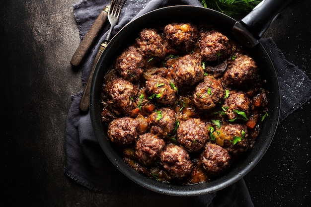 Gebratene Frikadellen mit Sauce auf Pfanne