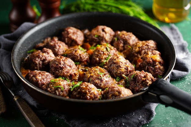 Gebratene Frikadellen mit Sauce auf Pfanne