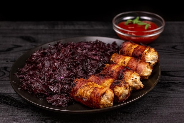 Foto gebratene hausgemachte gegrillte würstchen oder chevapchichi mit gedünstetem sauerkraut und tomatensauce auf rustikalem holzhintergrund.