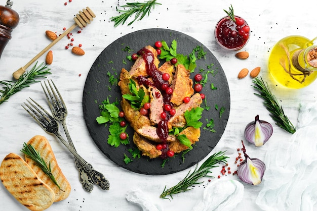 Gebratene Hühnerleber mit Preiselbeersauce und Preiselbeeren auf einer schwarzen Steinplatte Rustikale Ansicht von oben