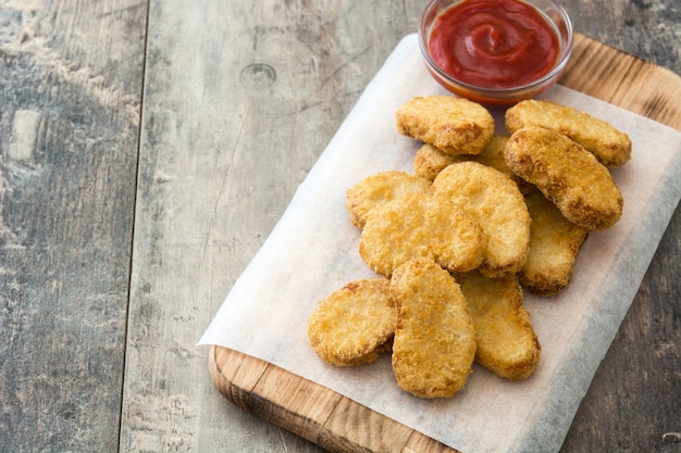 Foto gebratene hühnernuggets auf holztisch