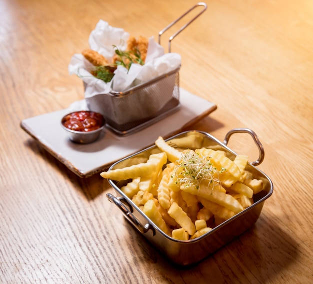 Gebratene Hühnernuggets mit Pommes Frites und Tomatensauce. Restaurant.