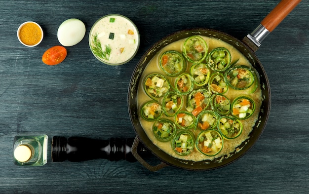 Gebratene junge geschnittene Zucchini in einer Pfanne auf einer dunklen Oberfläche