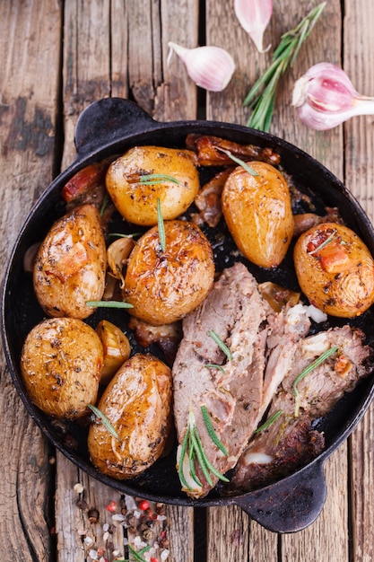 Gebratene junge Kartoffeln in der Pfanne. Mit Fleisch, Knoblauch, Speck