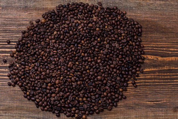 Gebratene Kaffeebohnen Kaffeebohnen auf einem hölzernen Hintergrund