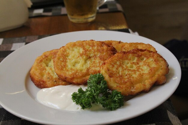 Foto gebratene kartoffel-pancakes mit frischer sahne, heißes gericht