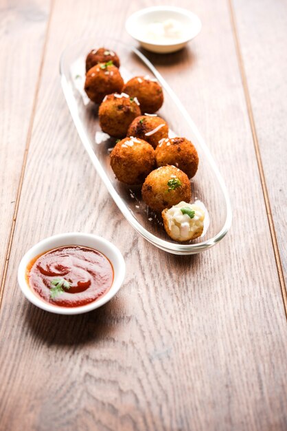 Gebratene Kartoffelkäsebällchen oder Kroketten mit Tomatenketchup. Selektiver Fokus