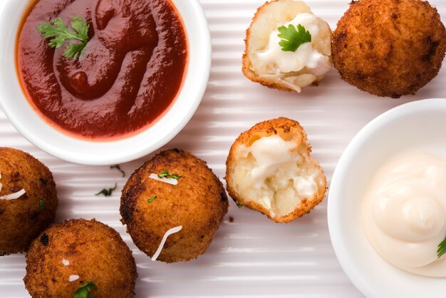 Gebratene Kartoffelkäsebällchen oder Kroketten mit Tomatenketchup. Selektiver Fokus