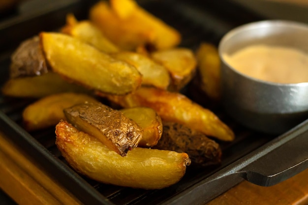 Gebratene Kartoffelkeile Pfanne mit Sauce Nahaufnahme