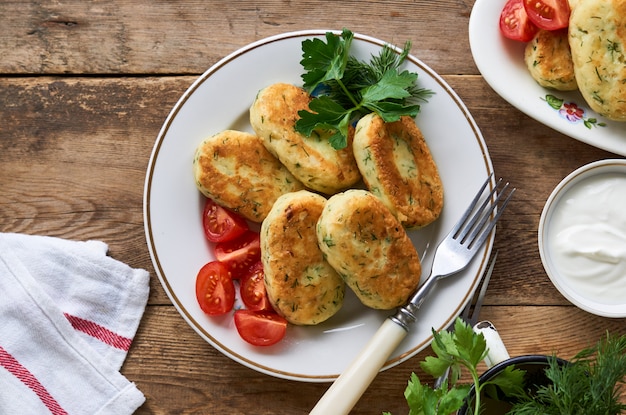 Gebratene Kartoffelkoteletts mit Dill auf einer weißen Platte