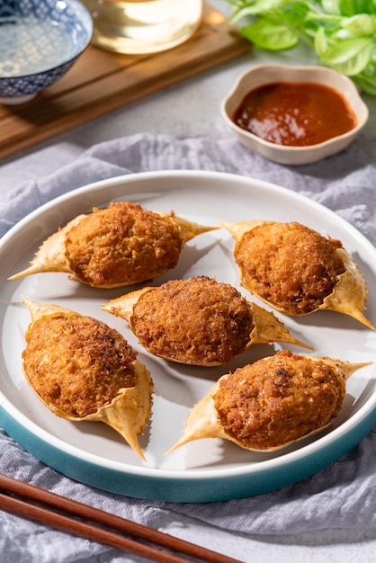 Gebratene knusprige Mini-Babykrabben oder Blue Swimmer Crab Rajungan oder Alimasag auf Teller mit Chilisauce