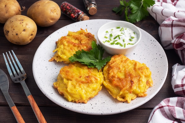 Gebratene Kuchen von geriebenen Kartoffeln auf dem Teller mit Sauce