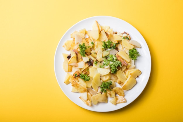 Gebratene Pommes Frites Kartoffeln auf gelbem Pfeffer