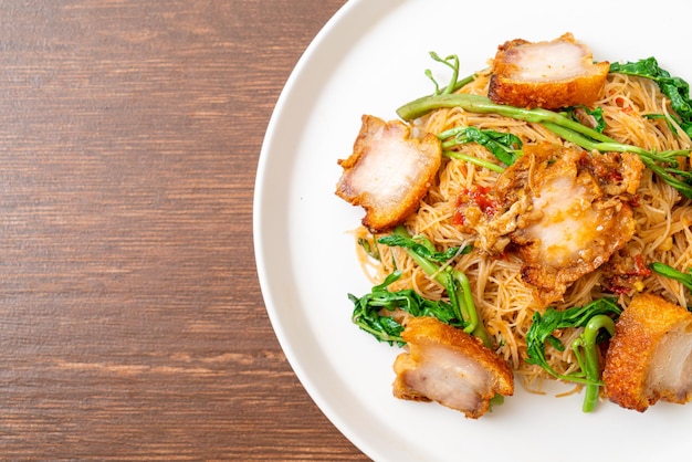 Gebratene Reisfadennudeln und Wassermimose mit knusprigem Schweinebauch - asiatische Küche