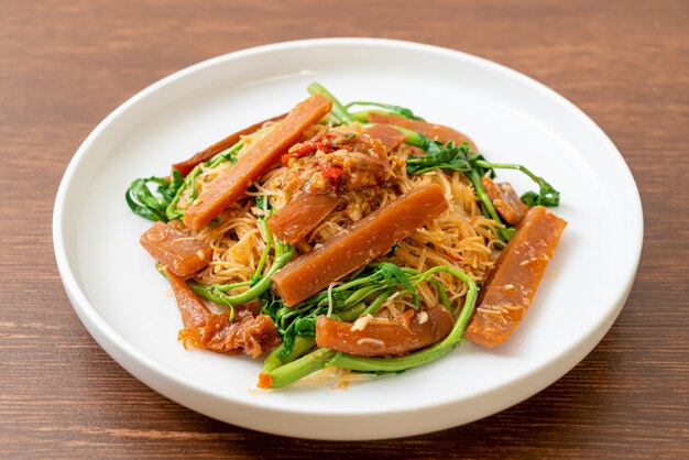 Gebratene Reisnudeln und Wassermimose mit eingelegtem Tintenfisch