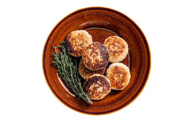 Gebratene Schweine- und Rinderfleischkoteletts oder Pastetchen in einem rustikalen Teller isoliert auf weißem Hintergrund