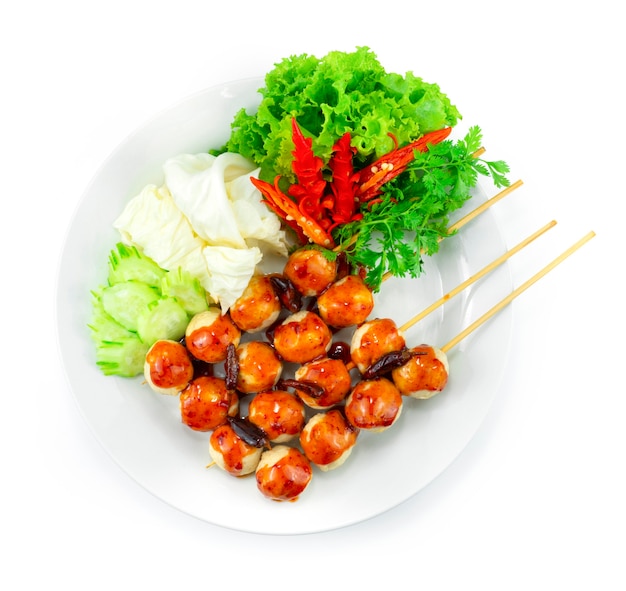 Gebratene Schweinebällchen am Spieß mit Fry Chili Spicy Sauce Thai Street Food Beliebte Dekoration Gemüse und geschnitzter Chili Draufsicht