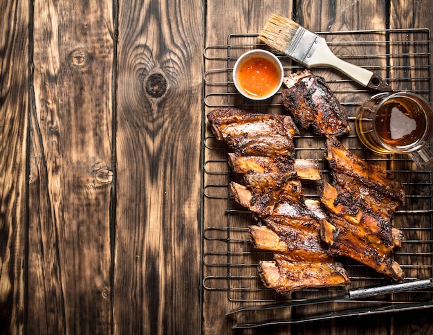 Gebratene Schweinerippchen mit Tomatensauce auf einem Holztisch