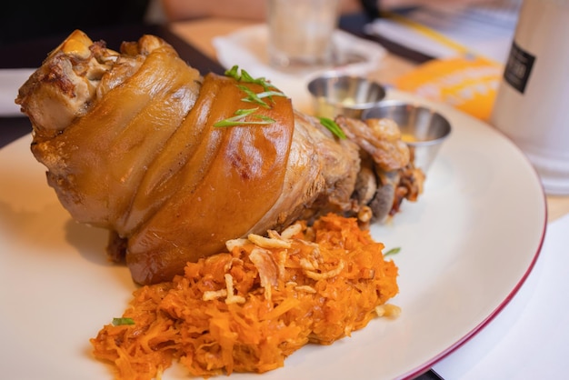 Gebratene Schweinshaxe Eisbein mit geschmortem Tafelspitz und Senf auf Holzbrett