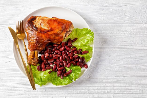 Gebratene Schweinshaxen mit roten Bohnen auf einem Teller