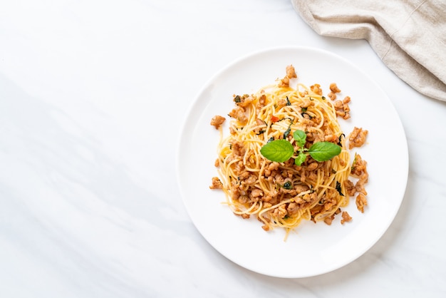 Gebratene Spaghetti mit gehacktem Schweinefleisch und Basilikum