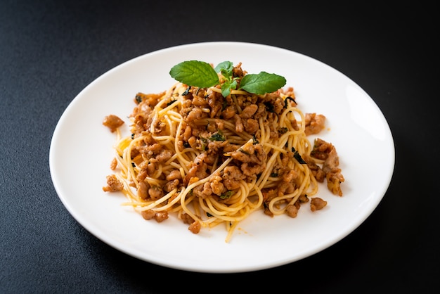 Gebratene Spaghetti mit gehacktem Schweinefleisch und Basilikum