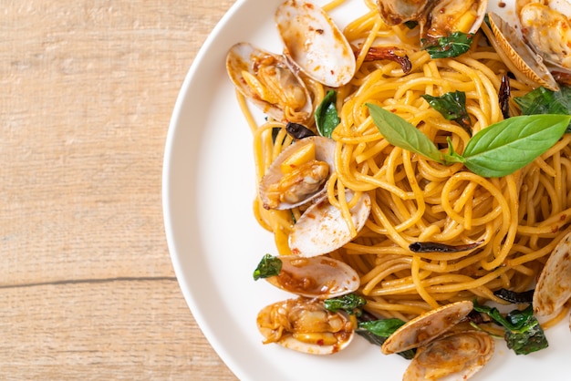 Gebratene Spaghetti mit Muscheln, Knoblauch und Chili umrühren