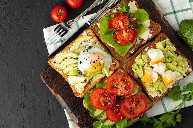 Gebratene Toasts mit Avocado und Ei sowie mit Frischkäse und Tomaten