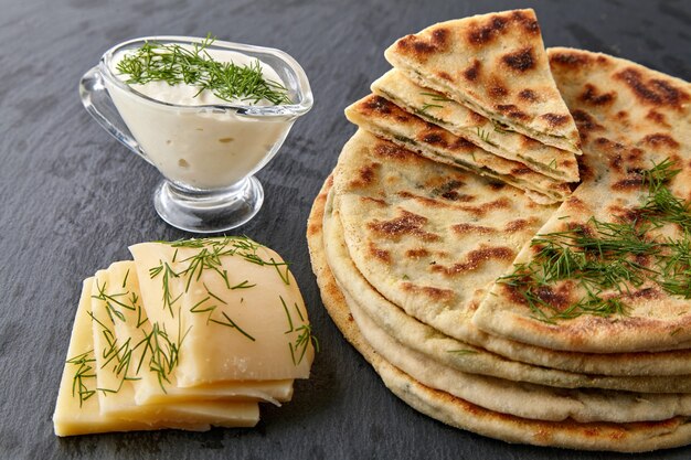 Gebratene Tortillas mit Käse und Kräutern und Joghurtsauce auf einem weißen Teller