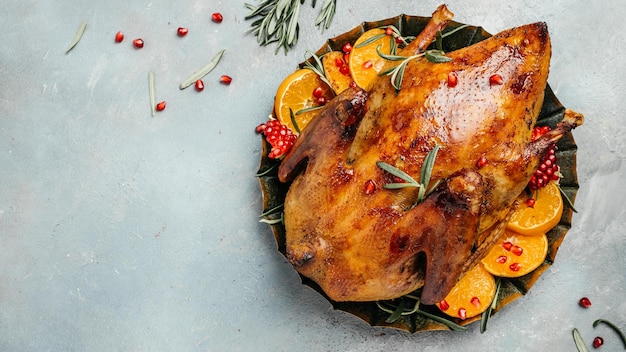 Gebratene Weihnachtsente mit Rosmarin und Orangen auf rustikalem Holztisch Traditionelle geröstete gefüllte Weihnachts-Peking-Ente