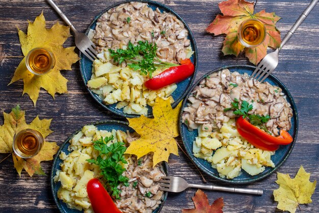 Gebratene wilde Steinpilze und Bratkartoffeln auf Teller, Nahaufnahme, Ansicht von oben. Ukraine